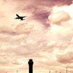 Airport tower and flying commercial airplane